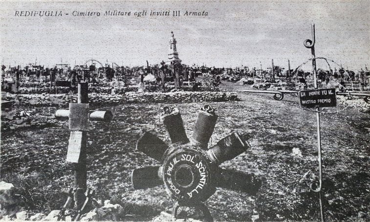 Gravestones and memorials in a cemetery with scattered flowers and decorations.