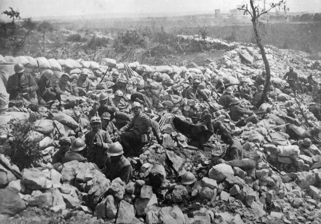 Ruined landscape with rubble and a lone tree, depicting devastation.