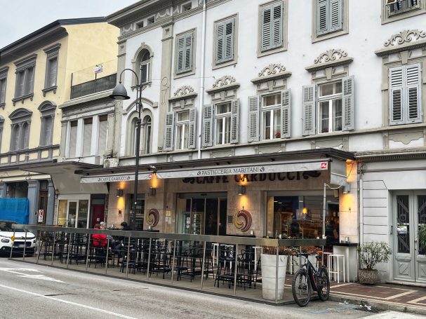Historic building with outdoor seating area and decorative windows.