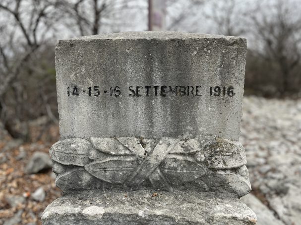 Stone monument engraved with the date 18-15-75 Septembre 1916 and decorative carving.