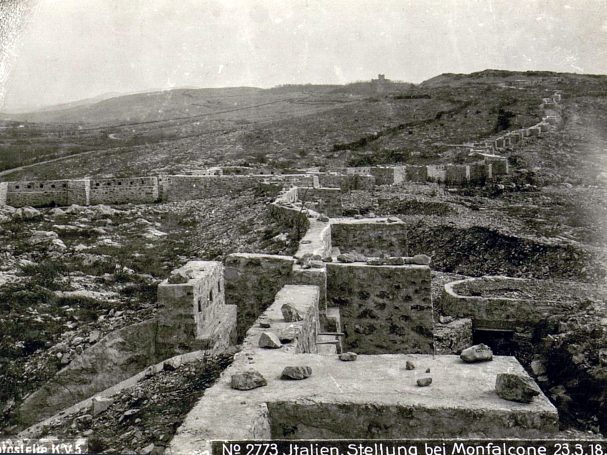 A historical black-and-white view of a mountainous landscape with buildings and ruins.