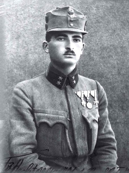 A young soldier in a military uniform with medals, posing for a portrait.